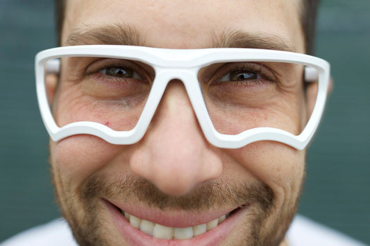 Male pickleball player wearing white Kitchen Blockers. High-performance lens-free eyewear designed for a secure fit, 100% peripheral vision, and zero fogging during intense court play